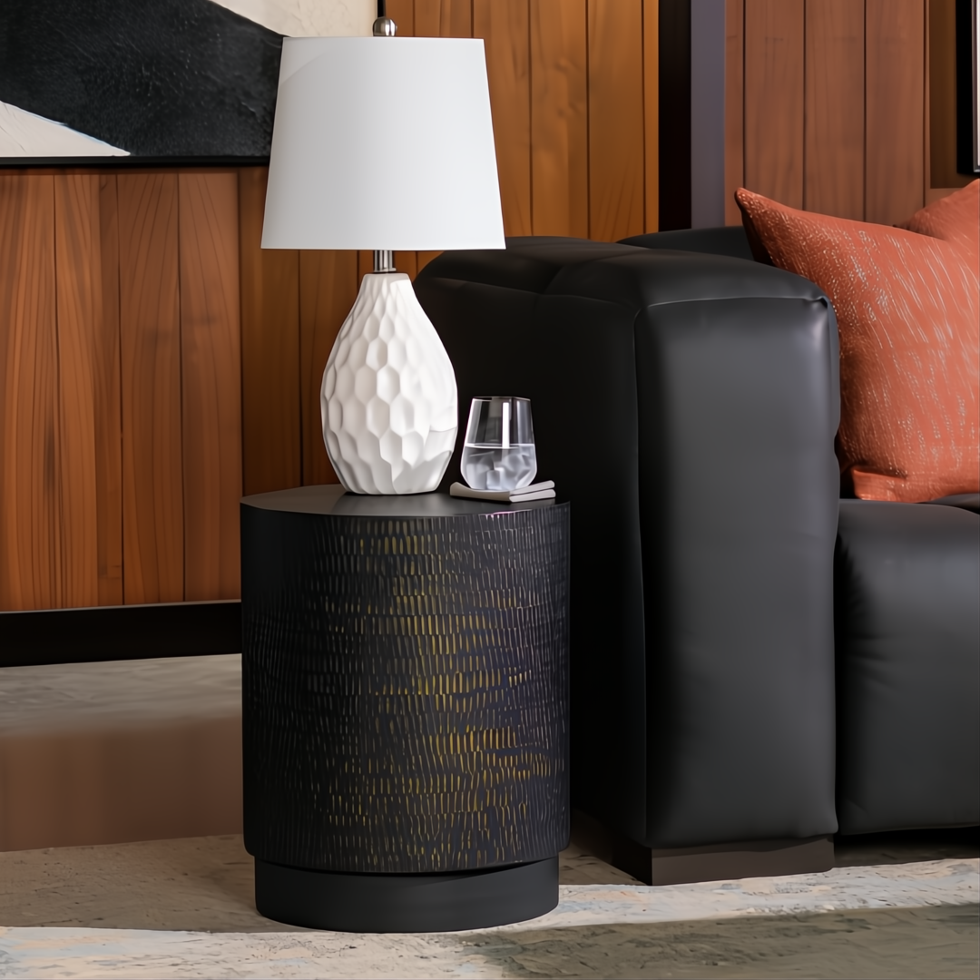 Surya Amenet black iron end table with hammered detail, 19"H x 15"W, next to a black sofa.
