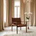 Modern Surya Chole accent chair with brown leather top and mango wood base in a styled room.