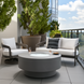 Gray hand-painted aluminum Surya Daniella Fire Table with glass beads on a modern patio.