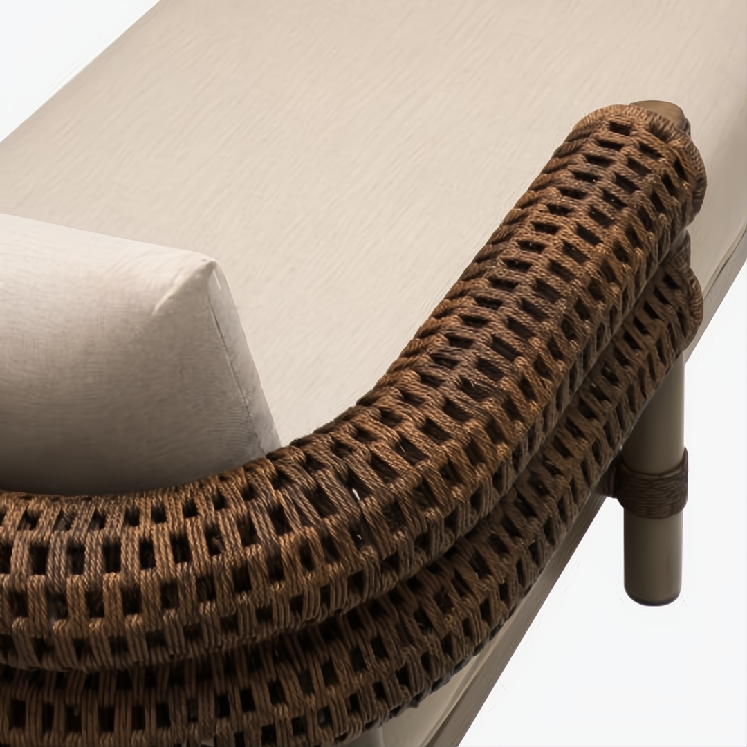 Brown woven armrest of a Surya Porta outdoor sectional with a light beige Sunbrella cushion.