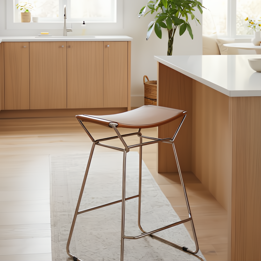 Modern brown leather counter stool with a metallic bronze iron base in a light kitchen.