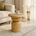 Beige mango wood Surya Koben End Table with a brushed finish, next to a sofa.