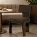 Dark gray upholstered Surya Sitara Dining Chair with a modern design, next to a marble table.