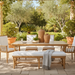 Surya Cape Town outdoor bench with wheat Sunbrella upholstery and aluminum frame, in a patio setting.