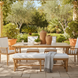 Surya Cape Town outdoor bench with wheat Sunbrella upholstery and aluminum frame, in a patio setting.