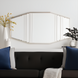 Modern elongated wall mirror with gilded metallic silver iron frame and beveled glass, above a dark sofa.