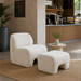 Ivory foam accent chair and matching ottoman on a jute rug in a modern lounge.