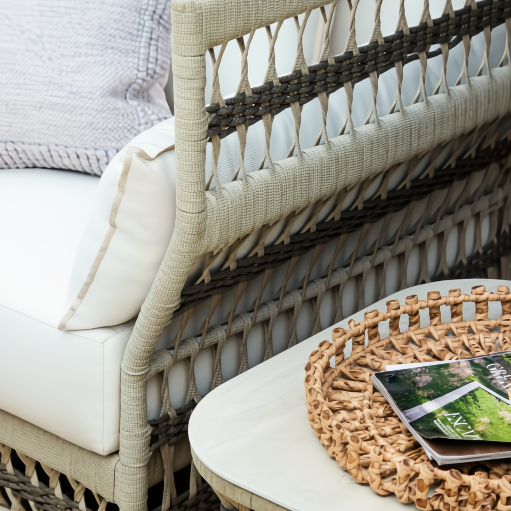 Cream aluminum outdoor end table with handwoven PE rope detail next to a patio chair.