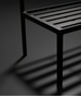 Black powder-coated aluminum base of a Surya Antibes dining chair with slatted design.