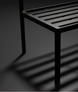 Black powder-coated aluminum base of a Surya Antibes dining chair with slatted design.