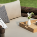 Surya Porta outdoor daybed with beige Sunbrella cushions, brown handwoven PE wicker, and a decorative tray.