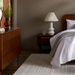 Brown Madri dresser with minimalist modern design, fluted top drawer, and tapered legs in a bedroom.