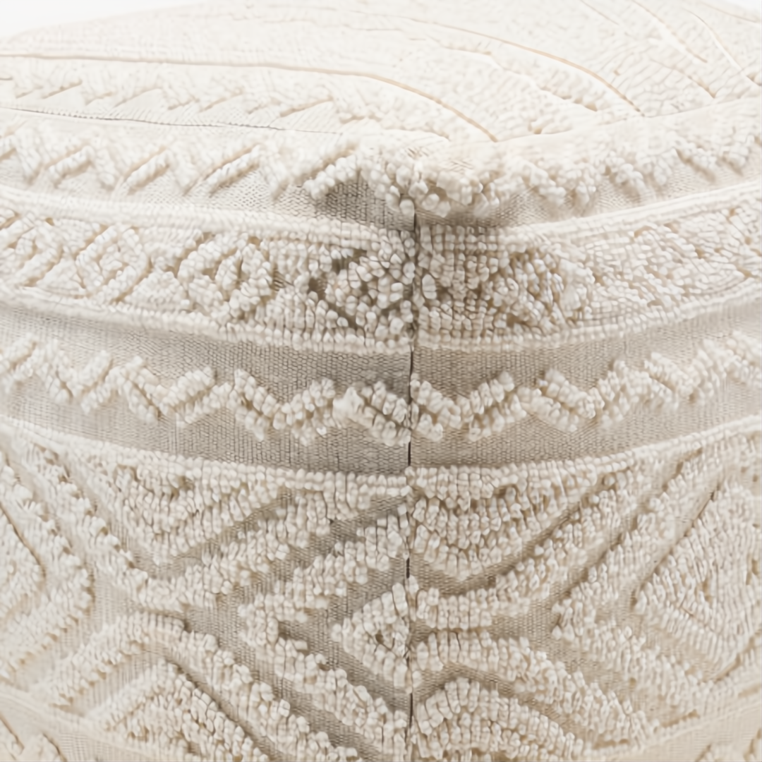 Close-up of a cream Surya Matthew pouf with a soft, textured knitted polyester cover and geometric patterns.