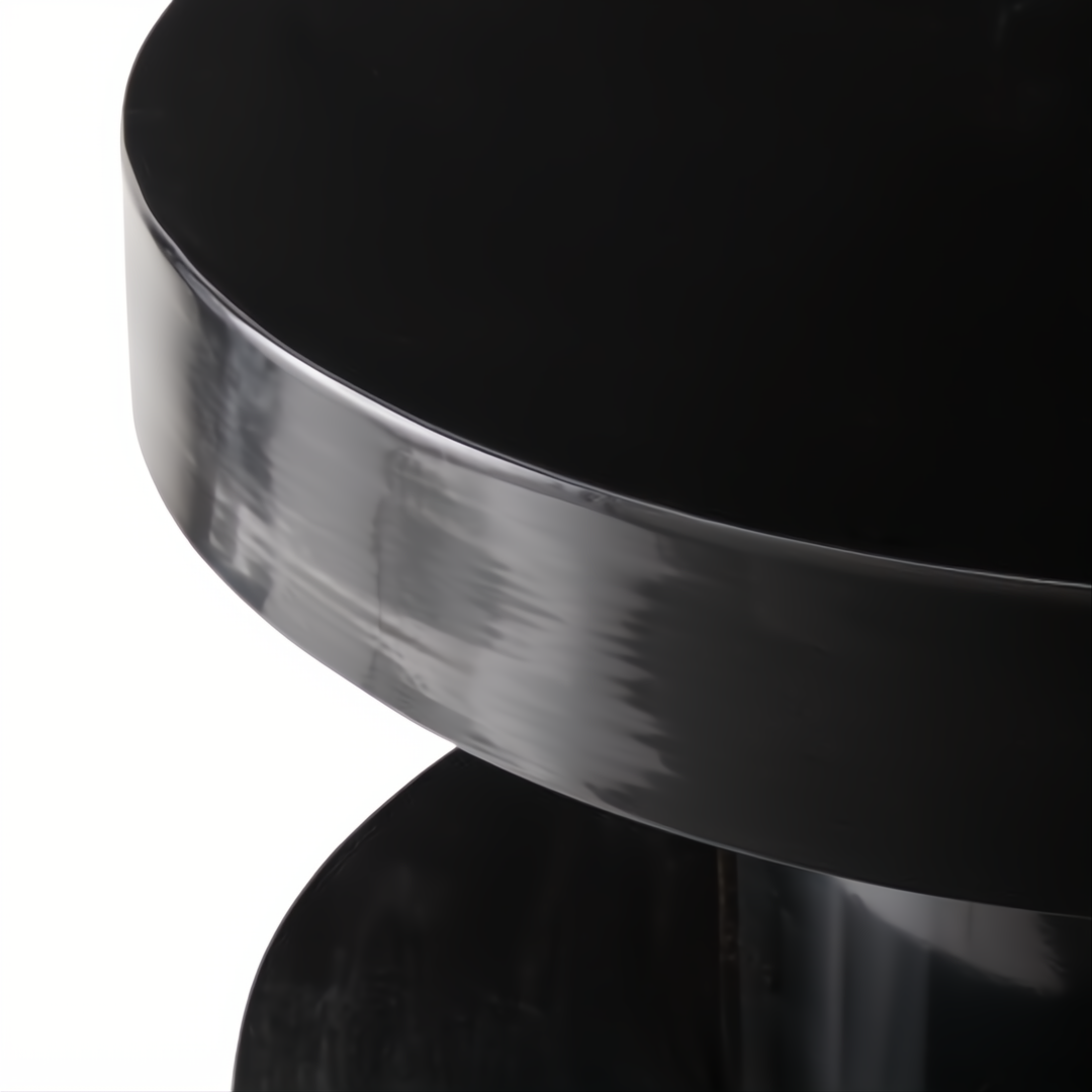 Minimalist modern black iron end table with a sleek, round top and base.