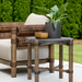 Surya Porta outdoor end table with dark brown matte stone top, brown aluminum base, and PE rope detail.