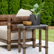 Surya Porta outdoor end table with dark brown matte stone top, brown aluminum base, and PE rope detail.