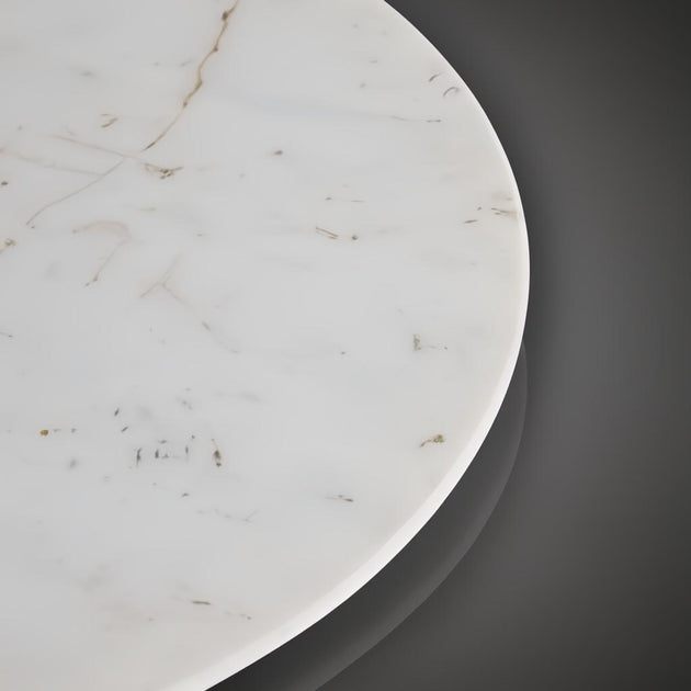Denali Accent Table with a round white marble top and subtle brown veining, against a dark background.