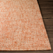 Surya Aiden AEN-1003 hand-tufted wool area rug in burnt orange and ivory, on a dark wood floor.