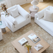 White Surya Capitola accent chair with three pillows, part of a living room set.