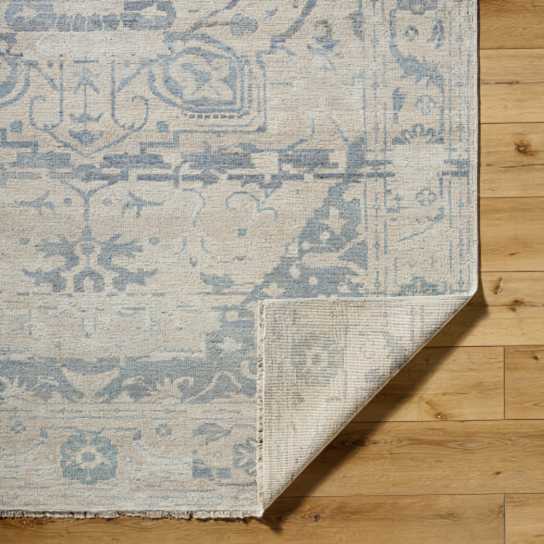 Hand-knotted Surya Cappadocia wool rug with light beige and blue traditional pattern, low pile, and fringe.