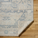 Hand-knotted Surya Cappadocia wool rug with light beige and blue traditional pattern, low pile, and fringe.