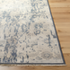Hand-knotted wool area rug with traditional charcoal, wheat, and taupe abstract design, low pile, and fringe.