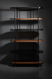 Modern Surya Pearson bookcase with dark brown wood, black tinted glass, and brass accents.