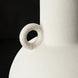 Close-up of a white textured ceramic decorative accent with a sculptural, vase-like form and a small ring handle.