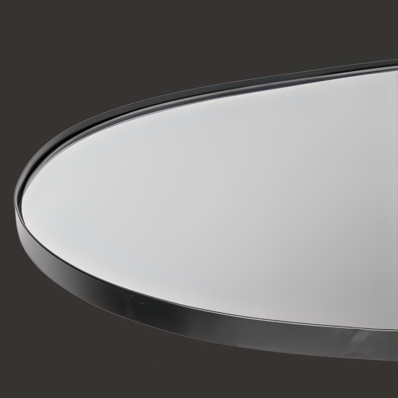 Close-up of a modern Surya Aamnah wall mirror with a black iron frame and beveled glass.