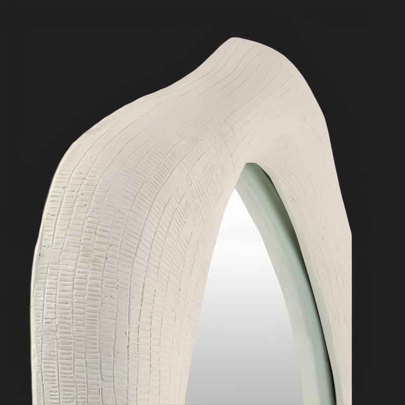White lacquered concrete accent mirror with a unique specialty shape and textured frame.