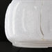 Close-up of Surya Bentley accent table lamp base, featuring clear seeded glass on a black surface.