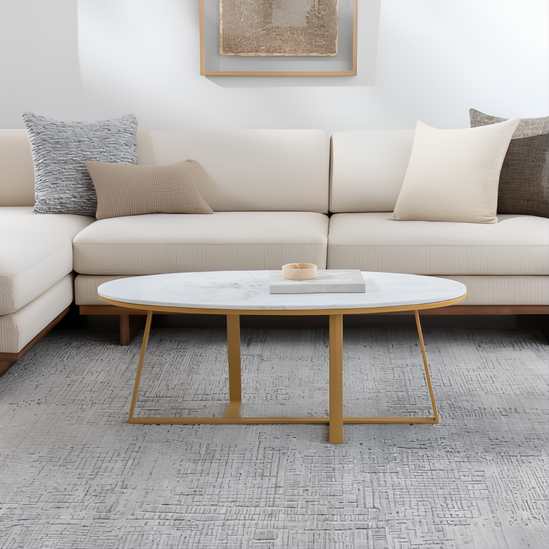 Surya Akola oval coffee table with white natural marble top and gold powder-coated iron base in a living room.