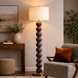 Surya Algarve 62" brown and gold floor lamp with stacked resin spheres, white linen shade, and black iron base.