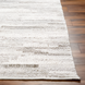 Hand-woven Surya Floria rug, light beige recycled PET yarn, low-profile texture on wood floor.