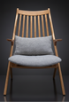 Mid-century modern accent chair with light wood frame and gray upholstered seat and lumbar pillow.