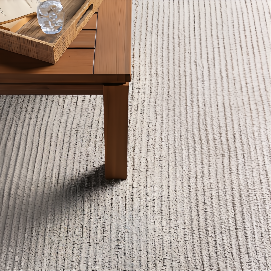Surya Azalea AZA-2315 hand-woven rug, light beige recycled PET yarn, with a wooden table.