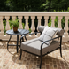 Surya Antibes black aluminum accent chair with striped Sunbrella cushion and white decorative pillow on a patio.