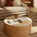 Surya Redondo beige marble and ribbed mango wood coffee table with books and decor.