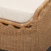 Close-up of a Surya Marvella Ottoman, featuring a light beige cushion on a natural wicker-style base.