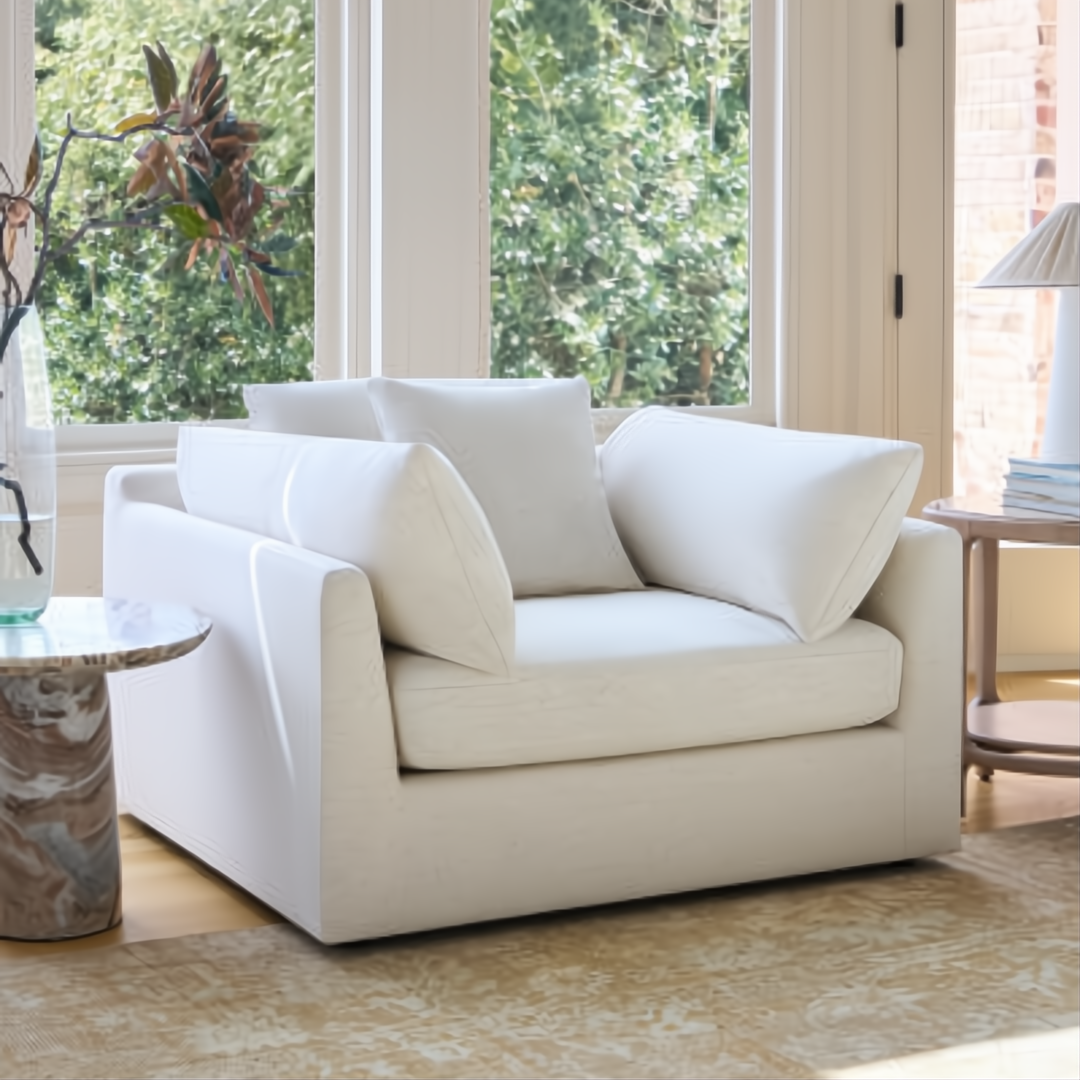 Surya Capitola white upholstered accent chair with three pillows, a clean, relaxed design.