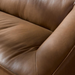 Close-up of a brown leather Surya Alba sofa with cushioned seating and a refined design.