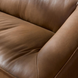 Close-up of a brown leather Surya Alba sofa with cushioned seating and a refined design.