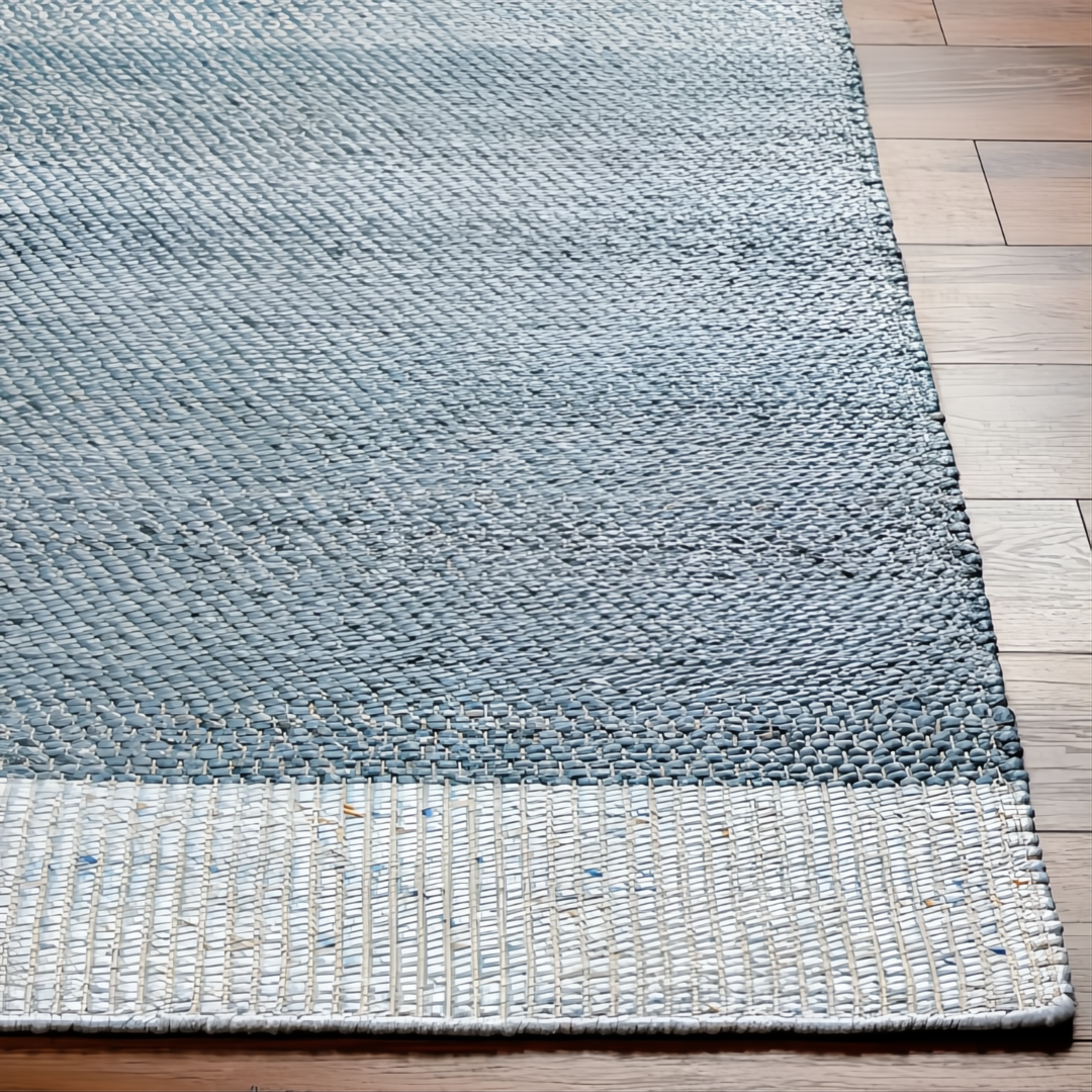 Hand-woven Surya Abby ABB-2302 area rug in blue and white recycled PET yarn on a wood floor.