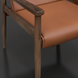 Modern Surya Chole accent chair with a tan leather seat and back, supported by a dark mango wood frame.