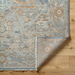 Surya Cappadocia wool rug in pale blue, gray, and taupe with traditional pattern and fringe.