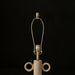 Surya Brava accent table lamp with a textured beige base, gold metal hardware, and an E-26 socket.