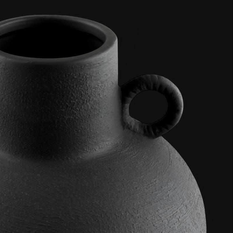 Close-up of a black ceramic decorative accent, featuring a textured finish and a small handle.