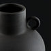 Close-up of a black ceramic decorative accent, featuring a textured finish and a small handle.