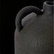 Close-up of a dark gray, textured ceramic decorative accent with a curved handle, against a black background.
