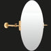 Oval wall mirror with a sleek, adjustable brass arm and mounting hardware, ideal for modern spaces.